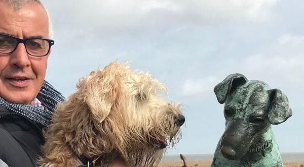 Ian Braid with his dog next to a dog statue
